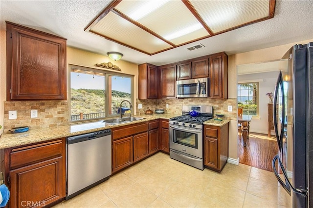 kitchen with appliances with stainless steel finishes, plenty of natural light, a sink, and visible vents