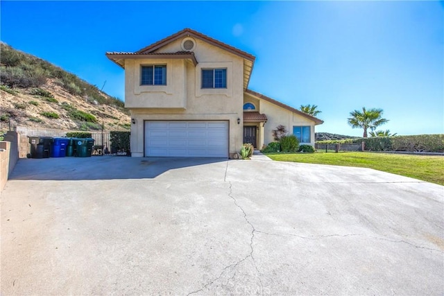 view of front of property featuring a garage, fence, concrete driveway, stucco siding, and a front lawn