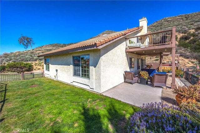 rear view of property with a yard, a patio, fence, and stucco siding