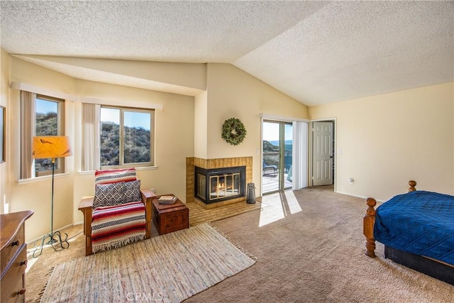 carpeted bedroom featuring a fireplace with flush hearth, vaulted ceiling, a textured ceiling, access to outside, and baseboards