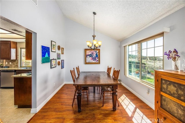 dining area with lofted ceiling, wood finished floors, visible vents, and an inviting chandelier