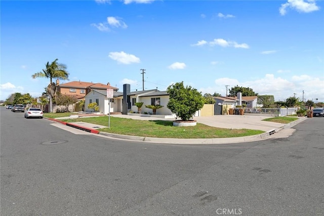 view of front of house with a front lawn, fence, and a residential view