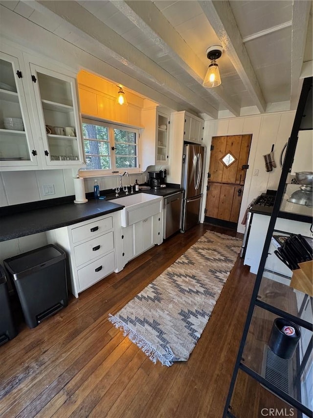 283 Walnut Dr, Lake Arrowhead, CA 92352 - kitchen with dark countertops, beam ceiling, stainless steel appliances, white cabinets, and dark wood-style flooring