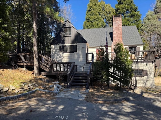 283 Walnut Dr, Lake Arrowhead, CA 92352 - view of front of property featuring stairway, a wooden deck, board and batten siding, and a shingled roof