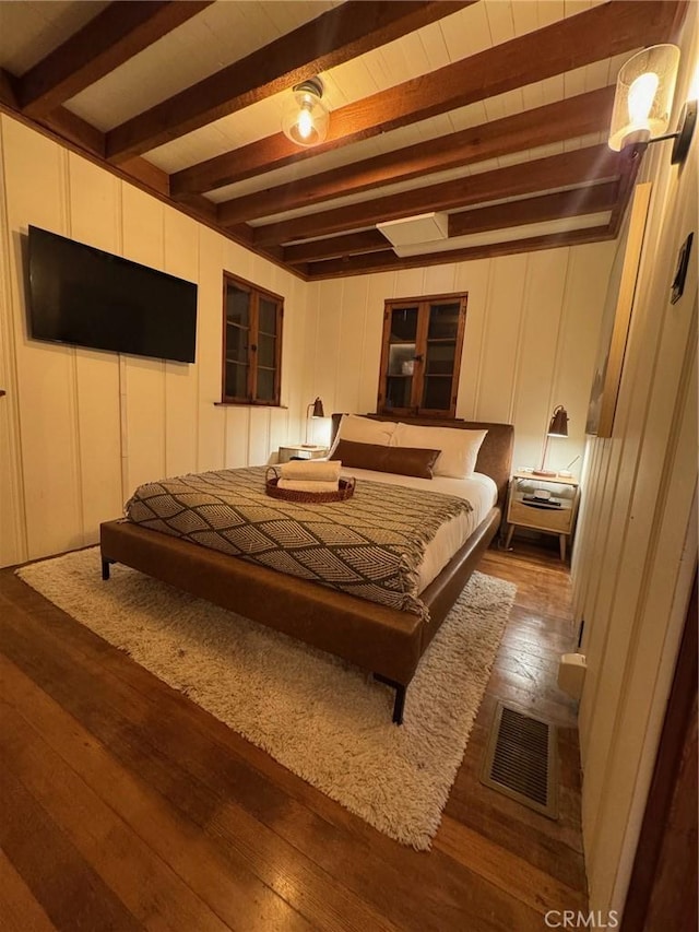 283 Walnut Dr, Lake Arrowhead, CA 92352 - bedroom with dark wood-style flooring, a decorative wall, and beam ceiling