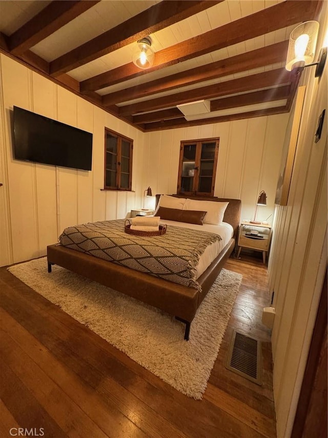 283 Walnut Dr, Lake Arrowhead, CA 92352 - bedroom featuring dark wood-style flooring, a decorative wall, and beamed ceiling