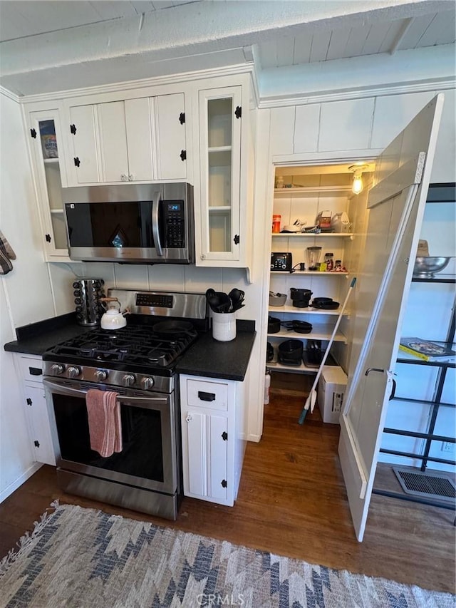 283 Walnut Dr, Lake Arrowhead, CA 92352 - kitchen with stainless steel appliances, dark wood-type flooring, dark countertops, and white cabinetry