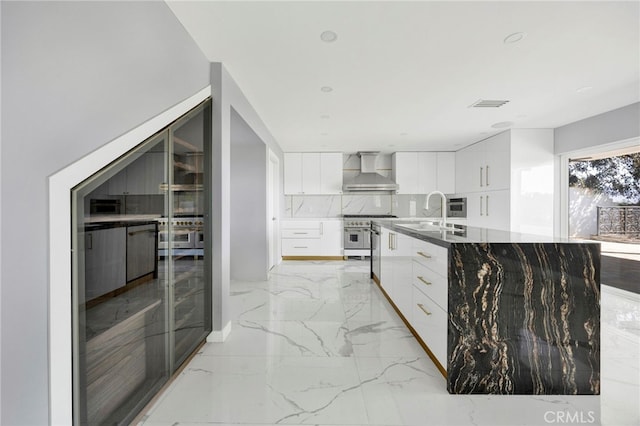 kitchen with wall chimney range hood, modern cabinets, marble finish floor, and a sink