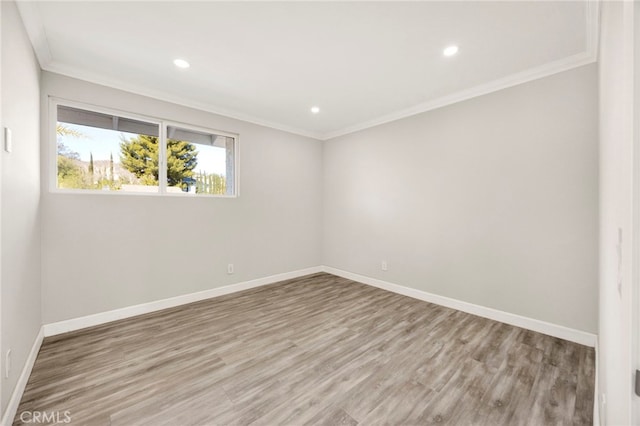 spare room with crown molding, recessed lighting, wood finished floors, and baseboards