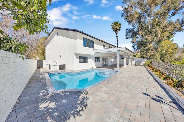 view of pool featuring a pool with connected hot tub, a fenced backyard, and a patio