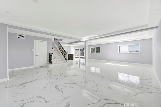 unfurnished living room with marble finish floor, visible vents, stairway, and baseboards