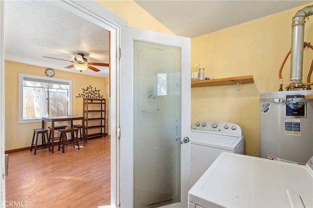 clothes washing area with electric water heater, laundry area, separate washer and dryer, a ceiling fan, and light wood-style floors