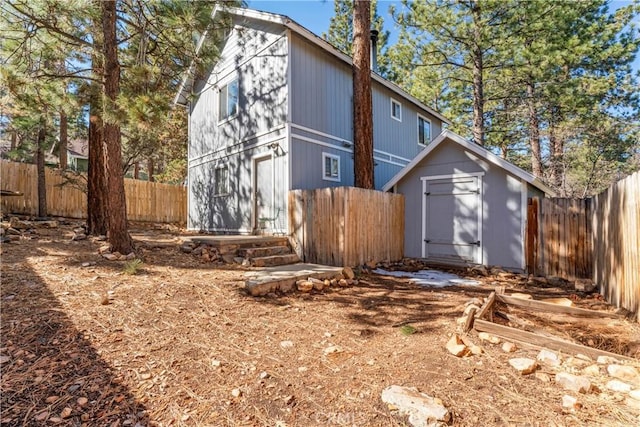 view of side of home with an outbuilding, a shed, and a fenced backyard