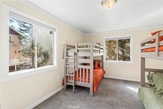 carpeted bedroom with multiple windows, crown molding, and baseboards