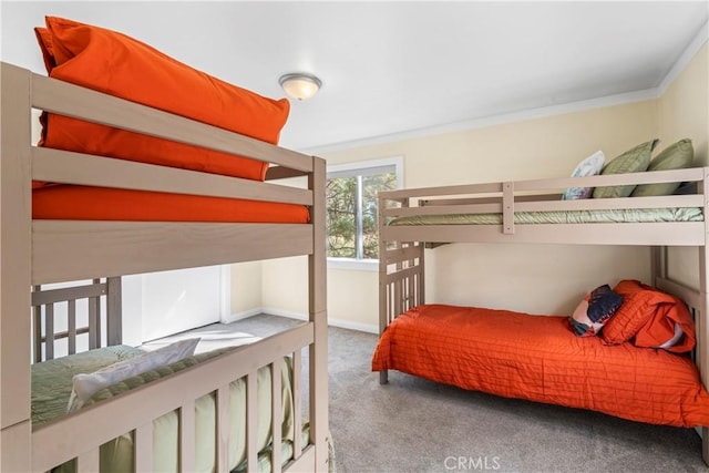 carpeted bedroom featuring ornamental molding and baseboards