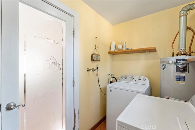 clothes washing area with washing machine and dryer, laundry area, and electric water heater