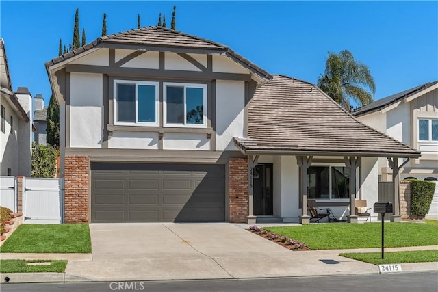 view of front of home with brick siding, fence, driveway, stucco siding, and a front yard