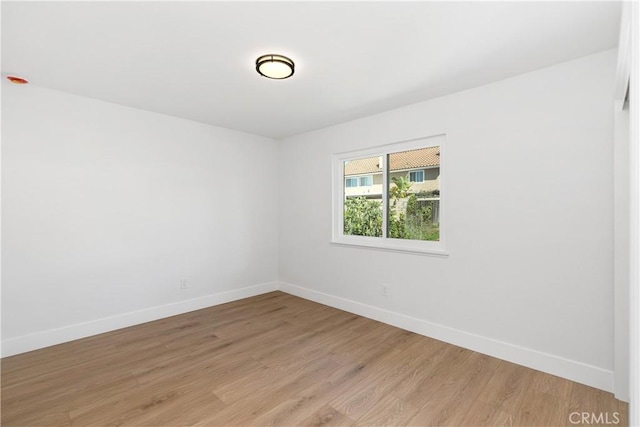 unfurnished room with light wood finished floors and baseboards