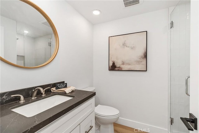 full bathroom featuring visible vents, baseboards, toilet, vanity, and a shower stall