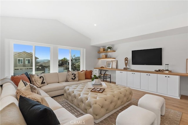 living area with light wood finished floors and high vaulted ceiling