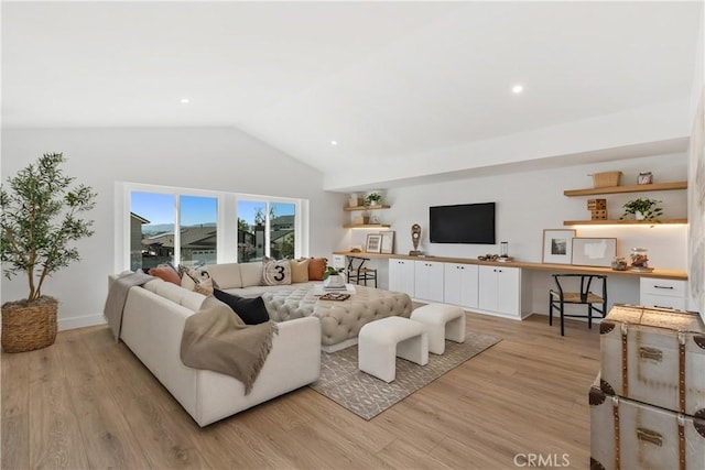 living area with light wood-type flooring, baseboards, and vaulted ceiling