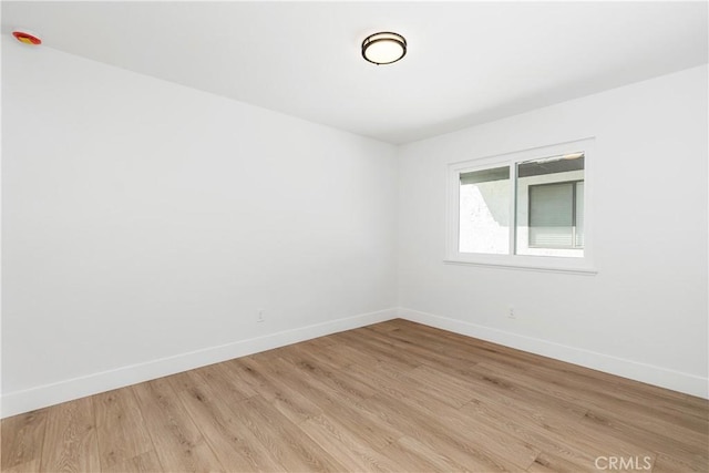 empty room featuring light wood-style floors and baseboards