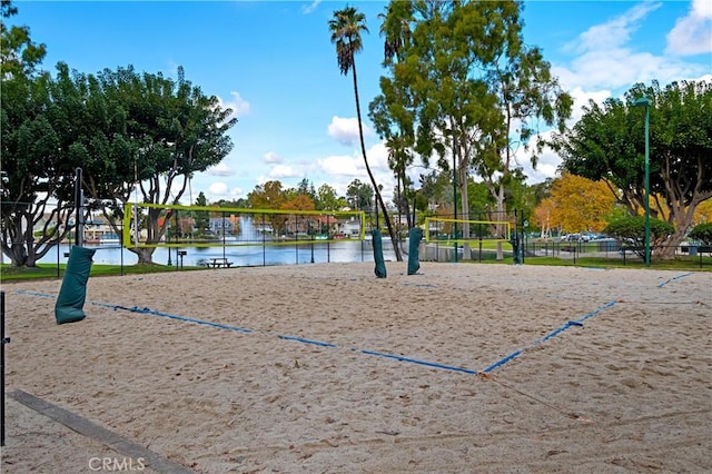 surrounding community featuring volleyball court and a water view