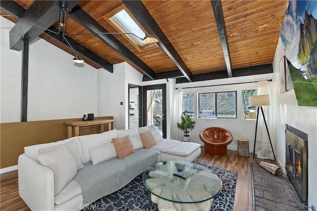 living area featuring a brick fireplace, wood finished floors, vaulted ceiling with skylight, wooden ceiling, and baseboards