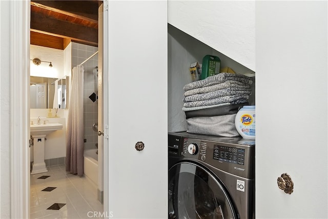 clothes washing area featuring washer / dryer, tile patterned flooring, and laundry area