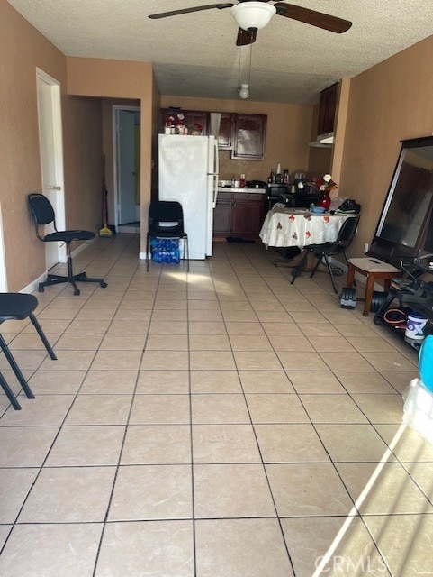 interior space with light tile patterned floors, ceiling fan, and a textured ceiling