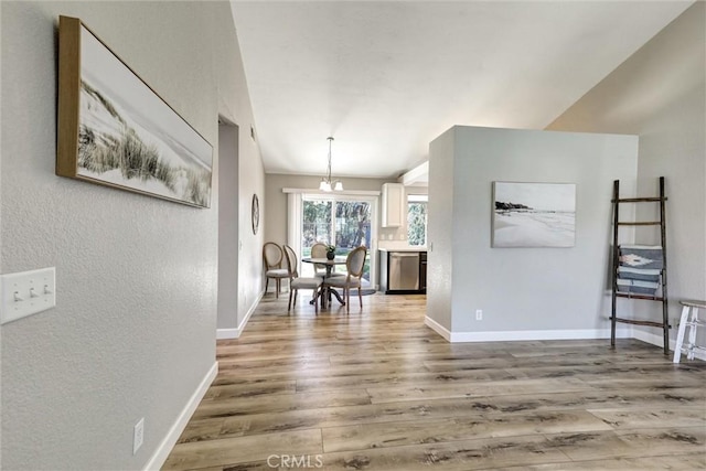 dining space with a textured wall, baseboards, and wood finished floors