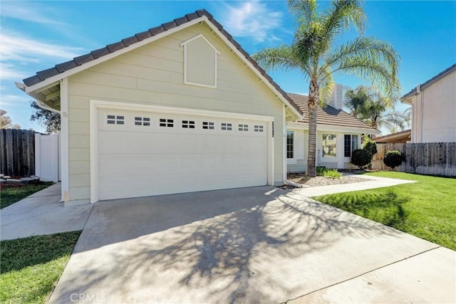 view of front facade featuring an attached garage, fence, a tile roof, concrete driveway, and a front yard