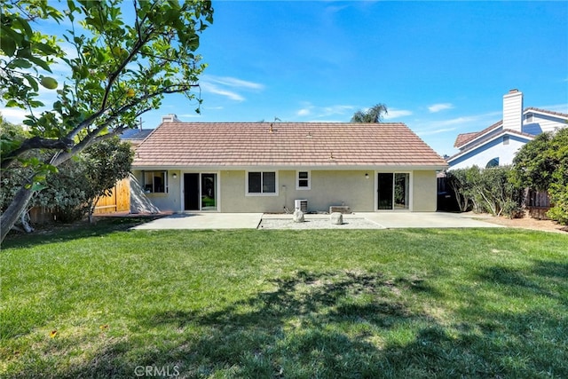 back of property with a yard, a patio, fence, and stucco siding