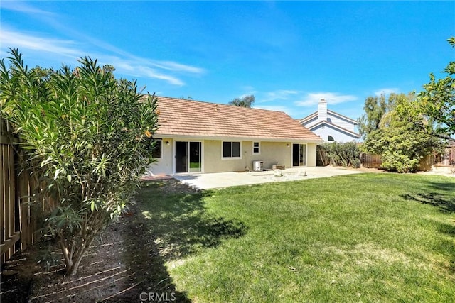 back of house with a patio, a fenced backyard, central air condition unit, a yard, and stucco siding