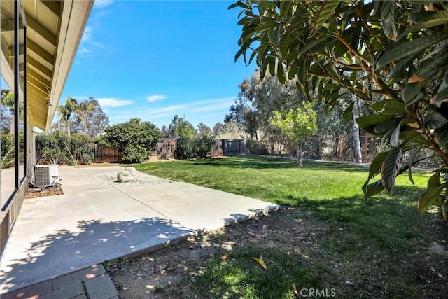 view of yard featuring central air condition unit, a fenced backyard, and a patio