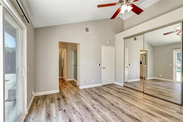 unfurnished bedroom with lofted ceiling, access to outside, light wood finished floors, and visible vents