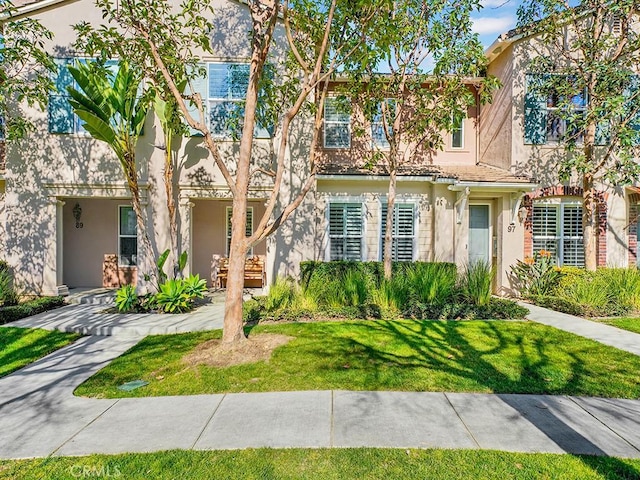 view of property with a front yard and stucco siding