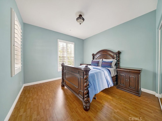 bedroom featuring wood finished floors and baseboards