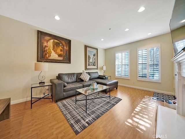 living area with baseboards, wood finished floors, and recessed lighting