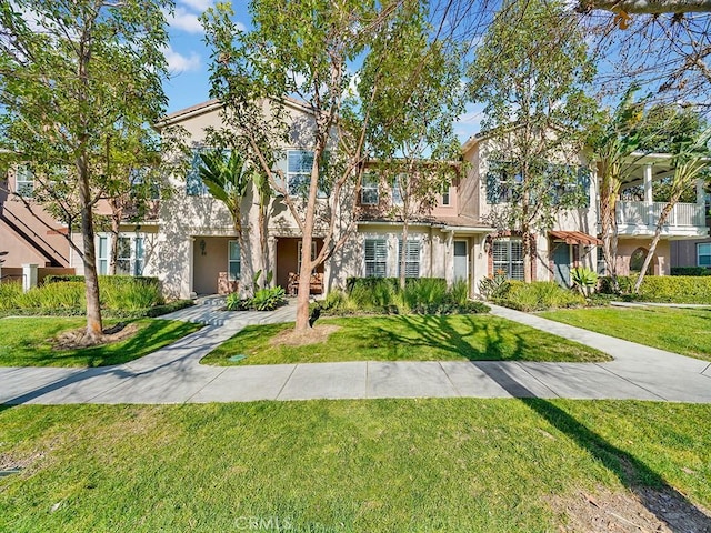 multi unit property with a front yard and stucco siding