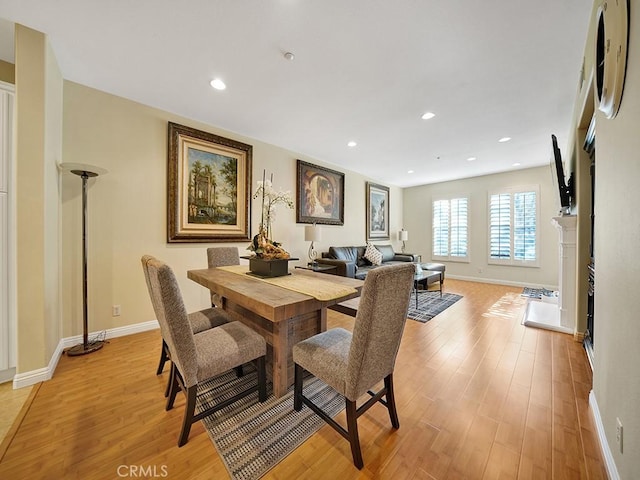 dining space with recessed lighting, a fireplace, light wood-style flooring, and baseboards