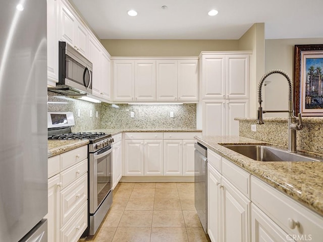 kitchen featuring stainless steel appliances, light tile patterned flooring, a sink, and decorative backsplash