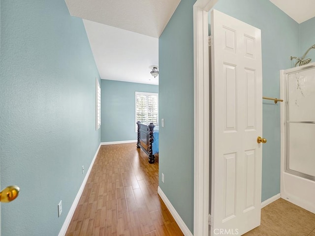 corridor with wood finished floors and baseboards