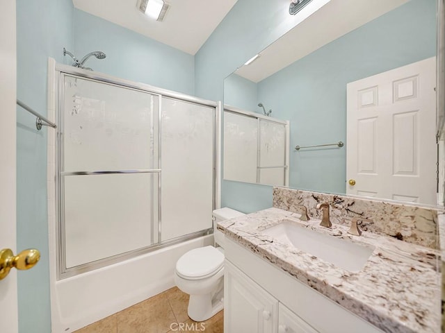 full bathroom featuring bath / shower combo with glass door, vanity, toilet, and tile patterned floors