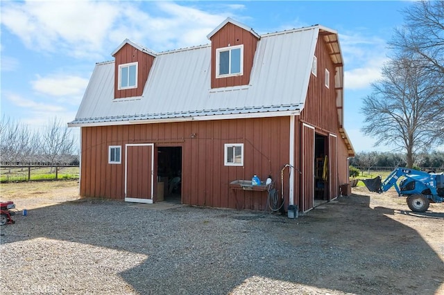 exterior space with a barn, a gambrel roof, metal roof, an outdoor structure, and a garage