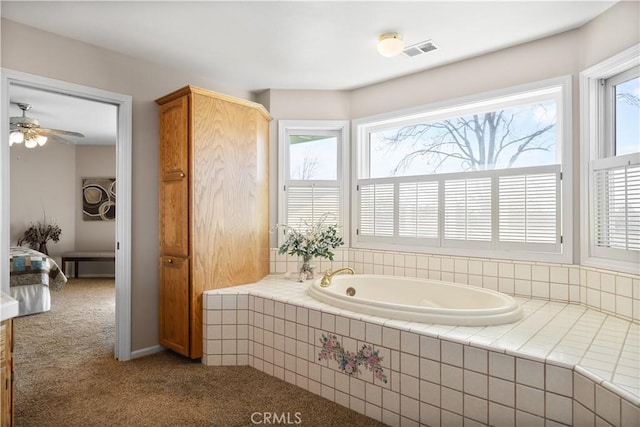 bathroom with a bath, visible vents, ensuite bathroom, and ceiling fan