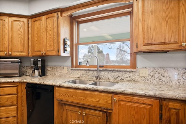 kitchen with brown cabinetry, a toaster, dishwasher, and a sink