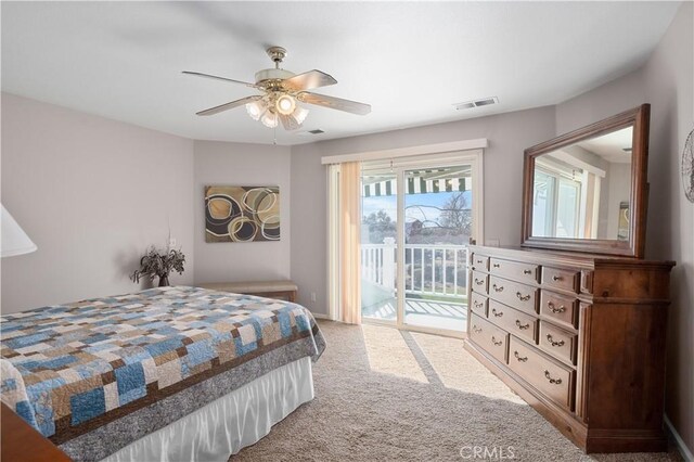 carpeted bedroom with access to exterior, visible vents, and ceiling fan