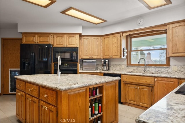 kitchen with black appliances, a sink, light stone counters, a center island, and wine cooler