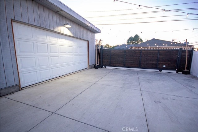 garage featuring fence and driveway